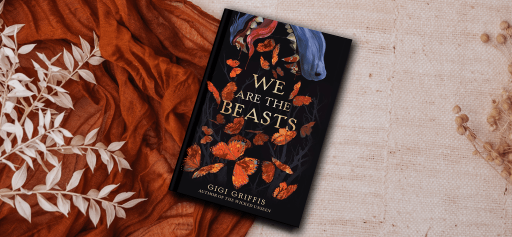 The cover of the novel We Are the Beasts by Gigi Griffis. It features the snout of a wolf snapping at orange, blood covered butterflies. The background shows tan foliage and an orange scarf.