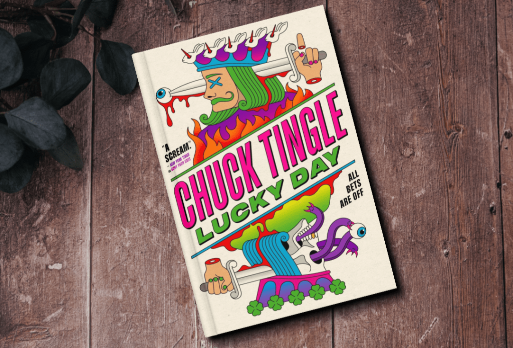 The cover of the book Lucky Day by Chuck Tingle. The cover features a king playing card design with the king stabbing himself in the back of the head with a sword.